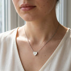 Collier en acier inoxydable à petit cœur gravé d'une initiale, porté au cou