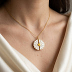 Collier marguerite doré porté au cou, pétales blancs et cœur jaune