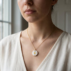 Collier marguerite doré porté au cou, pendentif fermé