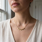 Collier doré à cœurs gravés d'initiales porté au cou