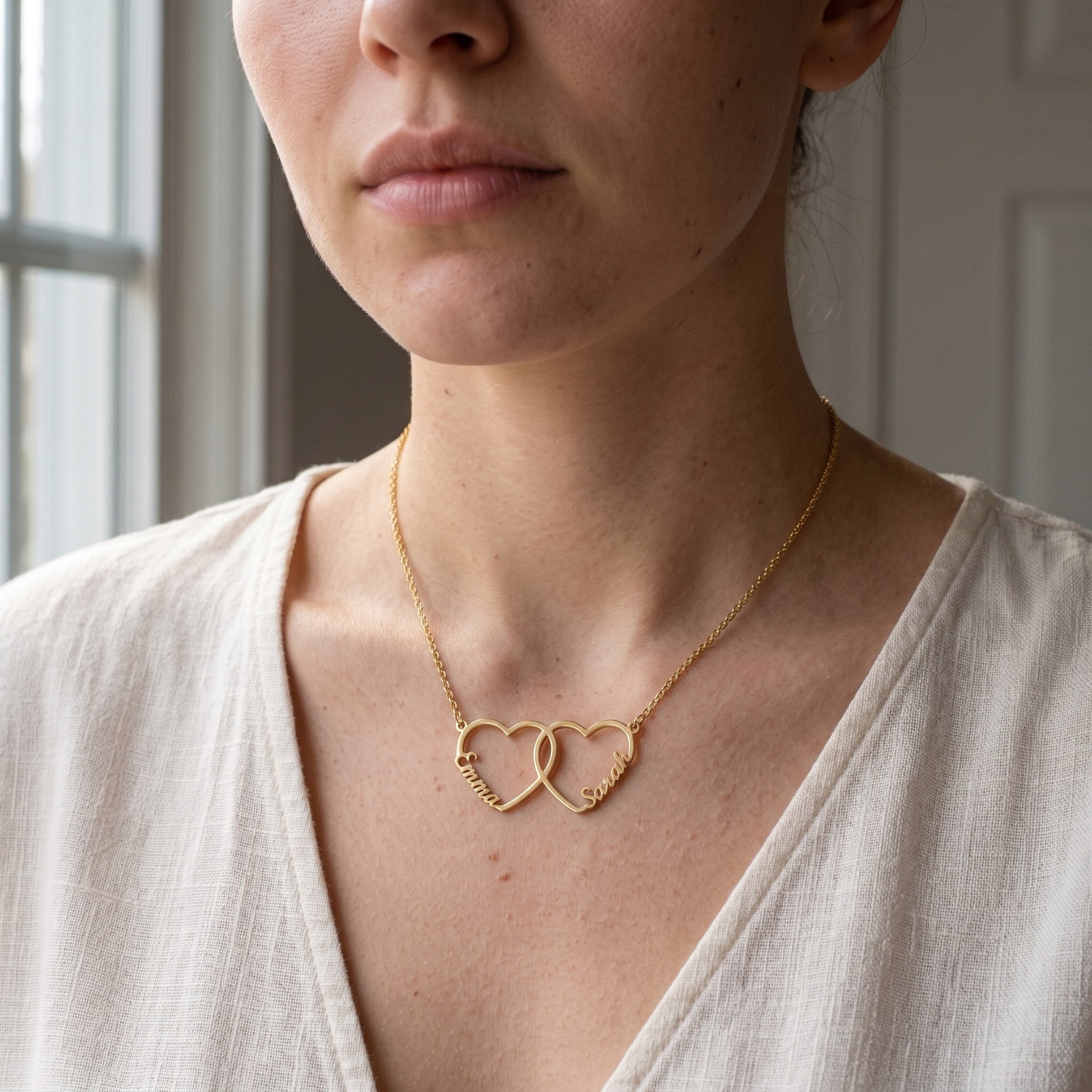 Collier deux cœurs entrelacés dorés porté au cou