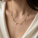 Collier doré à lettres majuscules porté au cou