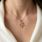Pendentif puzzle en or rose porté au cou, un prénom gravé