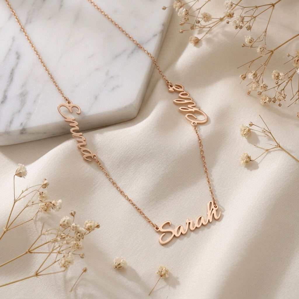 Collier en or rose à plusieurs prénoms suspendus, posé à plat