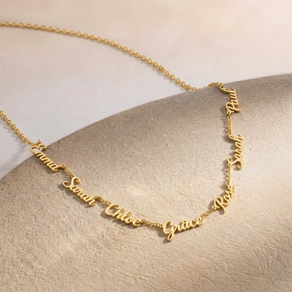 Gros plan sur un collier doré portant plusieurs prénoms sur une même chaîne