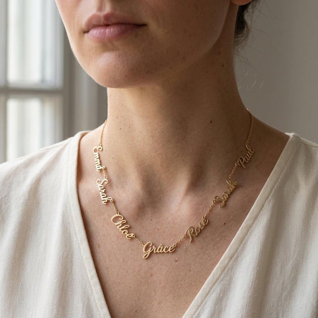 Collier en or rose à plusieurs prénoms porté au cou, vue rapprochée
