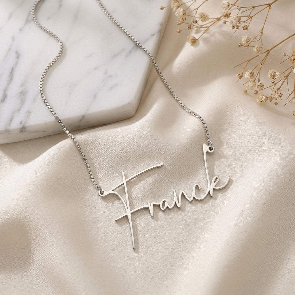 Collier prénom en acier inoxydable en écriture manuscrite, posé à plat