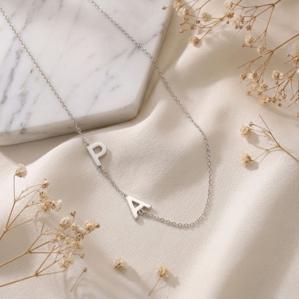 Collier en acier inoxydable aux lettres suspendues posé à plat