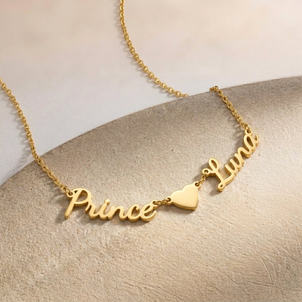 Gros plan sur un collier doré, deux prénoms manuscrits séparés par un cœur