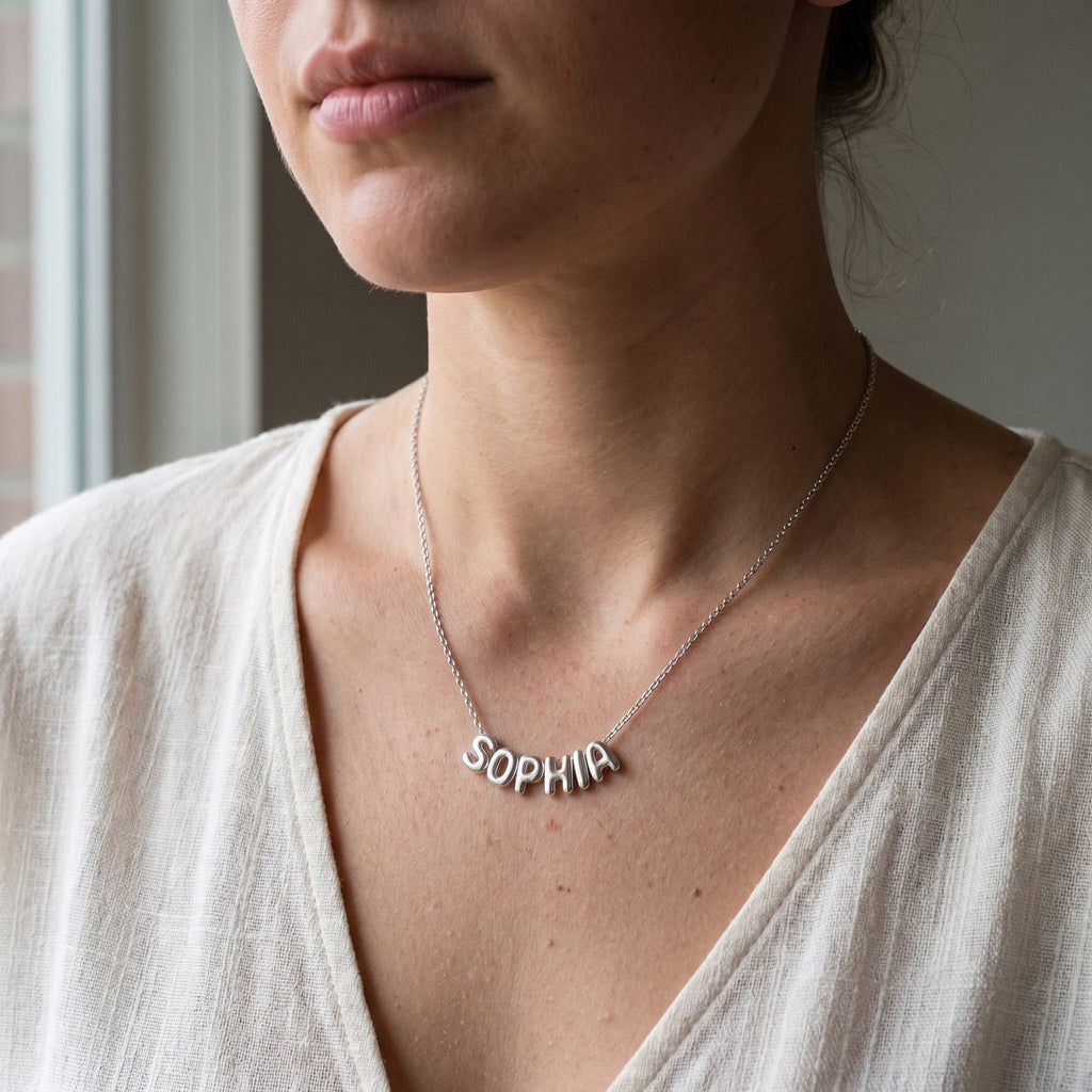 Collier en acier inoxydable à lettres bombées porté au cou