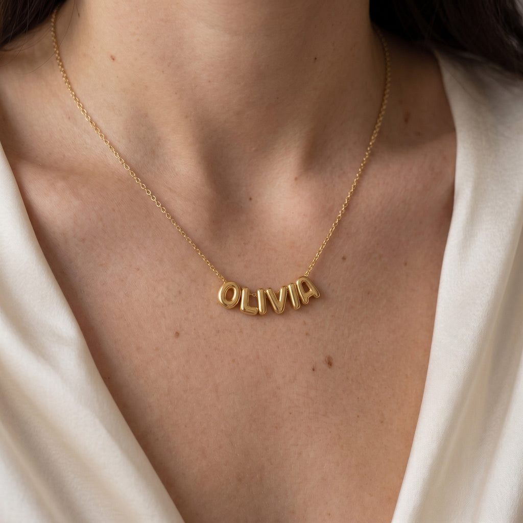Collier doré à lettres bombées porté au cou