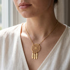 Collier attrape-rêves en or rose porté au cou, plumes gravées de prénoms